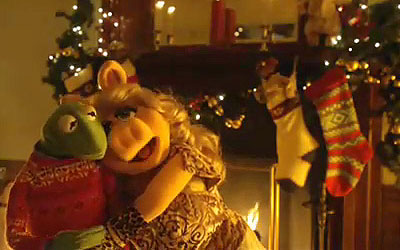 Kermit and Piggy snuggle beside the Christmas tree